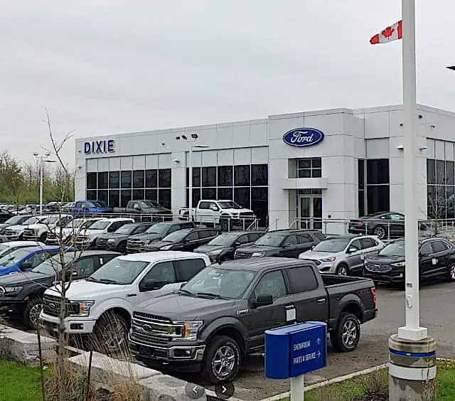 Exterior view of Dixie Ford dealership in Canada, showing a variety of Ford vehicles outside the building.