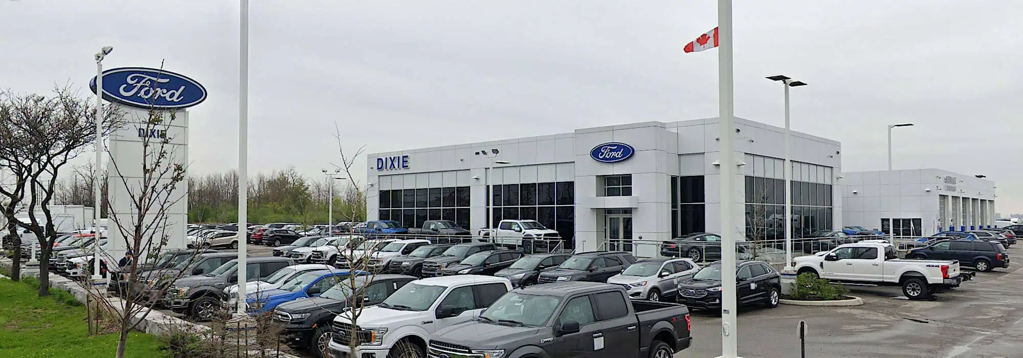 Exterior view of Dixie Ford dealership in Canada, showing a variety of Ford vehicles outside the building.